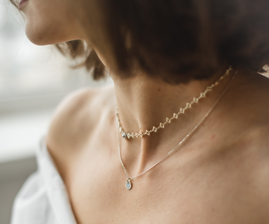 Girl with brown hair wearing dazzling necklaces.